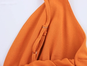 Détail de la boucle réglable argentée sur la bretelle orange en lin avec coutures