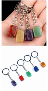 Detailed macro view showing diverse rectangle cut natural stone keychains in various colors