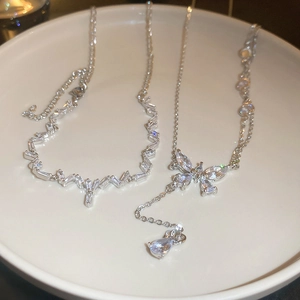 Elegant silver butterfly tassel necklace with sparkling cubic zirconia on a white plate