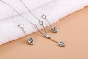 Macro shot of silver heart necklace and earrings set with shell inlay on plush texture