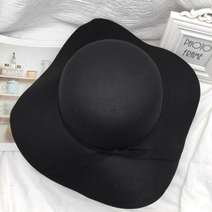 Elegant black wool felt cloche hat with a bow accent on a soft white background