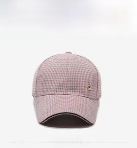 Detailed front view of pink and grey houndstooth baseball cap with golden logo