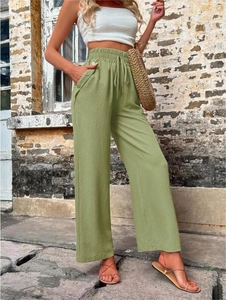 Détail du pantalon large vert à taille haute avec cordon de serrage et poches boutonnées
