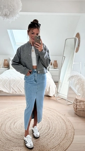 Mirror selfie showing a grey baseball jacket with a slit denim maxi skirt and sneakers