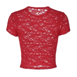 Détail du motif en dentelle florale rouge sur un haut ajusté à col rond et manches courtes