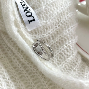 Polished silver irregular ring on white knit sweater with a minimalist aesthetic style