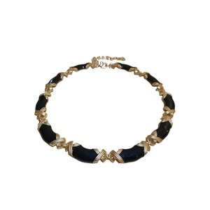 Collier vintage émaillé noir et or avec un design texturé croisé en métal lourd