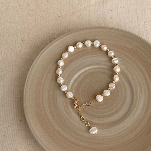 Macro view of natural baroque pearl bracelet with gold beads and a lobster clasp