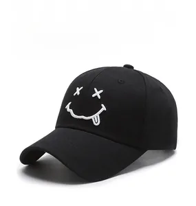 Close-up of white smiley face embroidery on a black cotton twill baseball cap