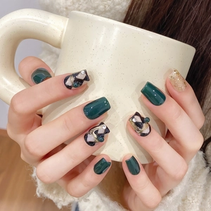 Emerald green hand-crafted press-on nails with checkered patterns and pearl accents