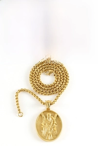 Détail d'un pendentif religieux en acier inoxydable doré 18K avec relief de saint
