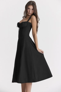 Side view of a black high-waisted slip dress with a flared skirt and minimalist chic style