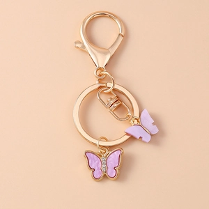 Detail of purple acrylic butterfly charm and gold rhinestone keychain for bags