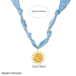 Detail of blue printed ribbon necklace with gold sun pendant and size measurements