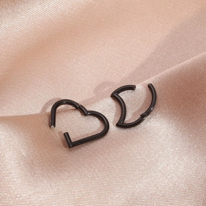 Close-up of black 316L stainless steel heart and moon seamless cartilage rings on silk