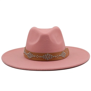 Detail of pink fedora hat featuring a brown leather band with silver metallic rivets