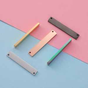 Detailed view of long rectangle stainless steel tags in gold, silver, and rose gold