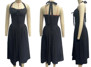 Detail view of black halter dress featuring tied bow, ruffle trim and flared skirt design