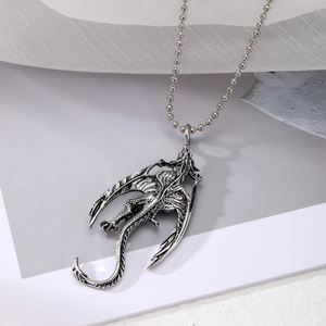 Close-up of vintage punk silver dragon pendant with detailed carving on a bead chain