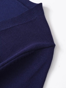 Detailed close-up of dark blue fine knit wool fabric texture and precision stitching