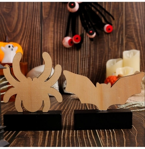Détail de décorations d'Halloween en bois avec araignée et chauve-souris sur fond rustique