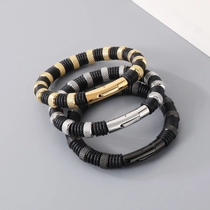 Stacked men's beaded bracelets in gold, silver, and black metal with rubber spacers