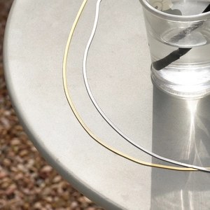 Ceintures minimalistes en chaîne serpent en acier titane doré et argenté sur fond gris