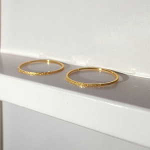 Detail of 18K gold plated minimalist rings showing shimmering sandblasted matte finish