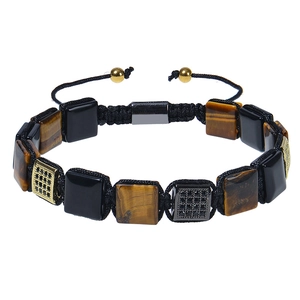 Detail of square tiger eye beads and black zircon metal charms on braided cord bracelet