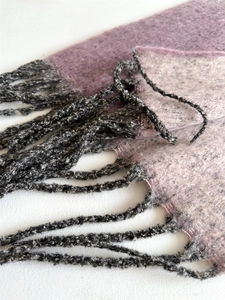 Close-up of pink and purple gradient scarf featuring soft cashmere-like texture and tassels