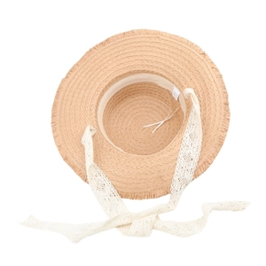 Detail of summer straw hat showing woven texture, fringe brim and white lace ribbon