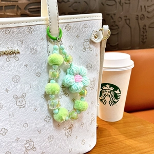 Ciondolo per borsa con fiore lavorato a maglia e pompon verde su borsa bianca