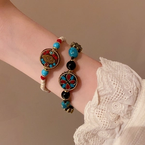 Bracelet ethnique en perles avec breloques colorées porté par un mannequin en style vintage