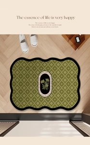 Detail of green wave-edged bath mat with clover pattern on a wooden floor