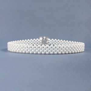 Close-up of white multi-row pearl belt featuring an elegant silver floral metal buckle