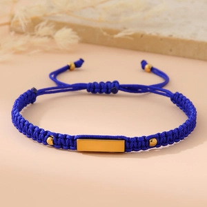 Close-up of blue braided cord bracelet with 18K gold-plated metal bar and beads