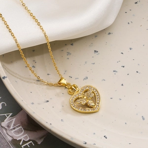 Detail of gold heart pendant with bee motif, crown top, and sparkling clear crystals