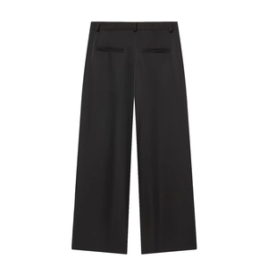 Detail of black wide-leg trousers featuring belt loops and smooth woven fabric texture
