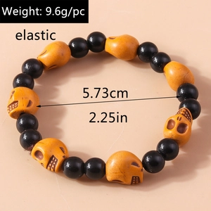 Detailed view of elastic Halloween bracelet with black beads and orange skulls