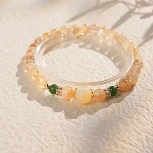 Vue détaillée d'un bracelet en perles de citrine jaune avec accents dorés et émeraudes