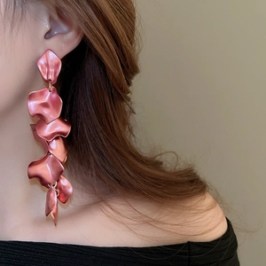Detail of matte pink layered petal long tassel earrings on model showing elegant drape