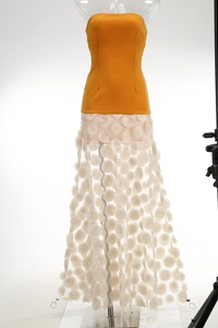 Close-up of orange strapless top and white sheer skirt with 3D polka dot applique