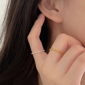Close-up of minimalist twisted stackable rings in gold and silver finish on finger