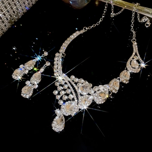 Macro shot of a silver necklace and teardrop earrings set with sparkling crystals