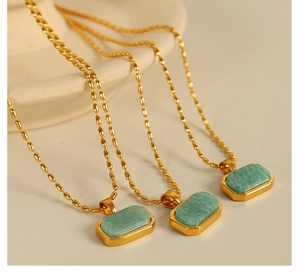 Macro detail of three golden beaded necklaces with rectangular green amazonite stone pendants