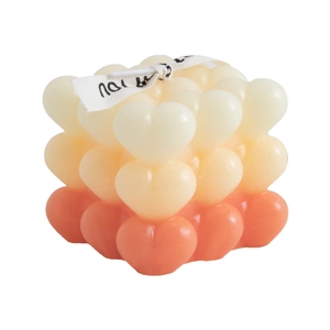 Gradient heart cube scented candle with decorative ribbon on a white background