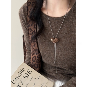 Macro shot of 81cm adjustable lariat necklace with leopard heart pendant on knitwear