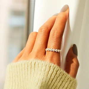 Elegant s925 sterling silver daisy ring with gold accents worn on a female finger