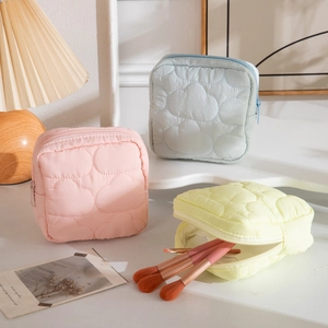 Quilted cloud-texture makeup bags in pastel pink blue and yellow with zipper closure