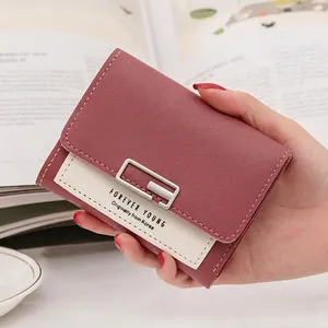 Close-up of pink and cream leather wallet with silver clasp and pebble texture
